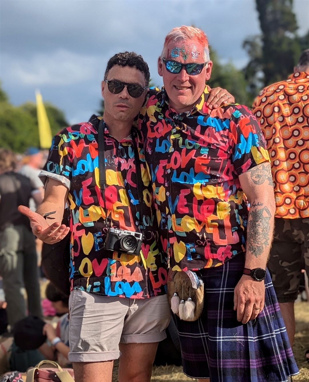 Two men wearing matching colourful shirts.