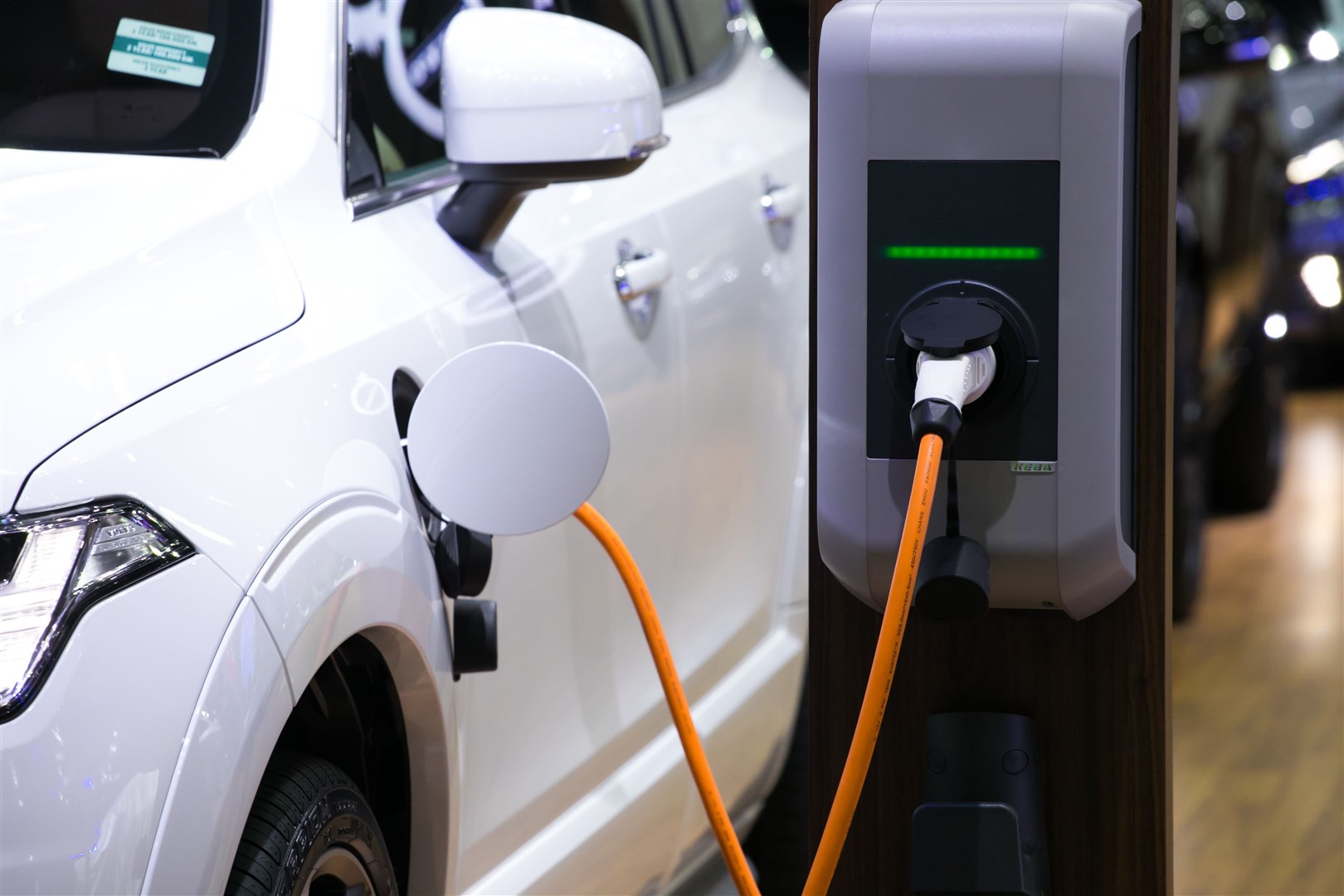 Close up of the power supply plugged into an electric car being charged.