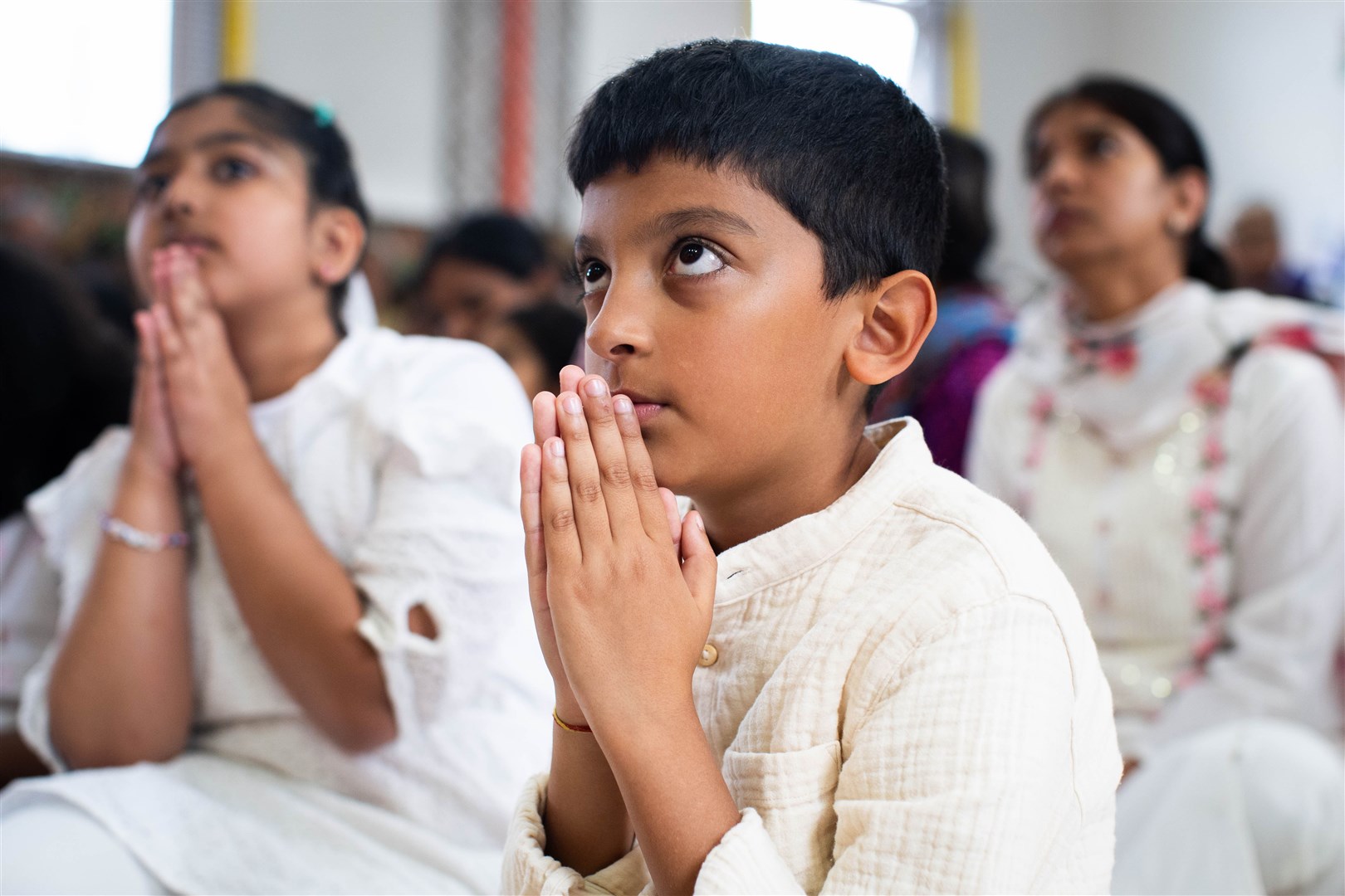 People attend a multi-faith vigil at the Siddhashram Shakti Centre in Harrow, London, for the victims of the Air India crash (James Manning/PA)