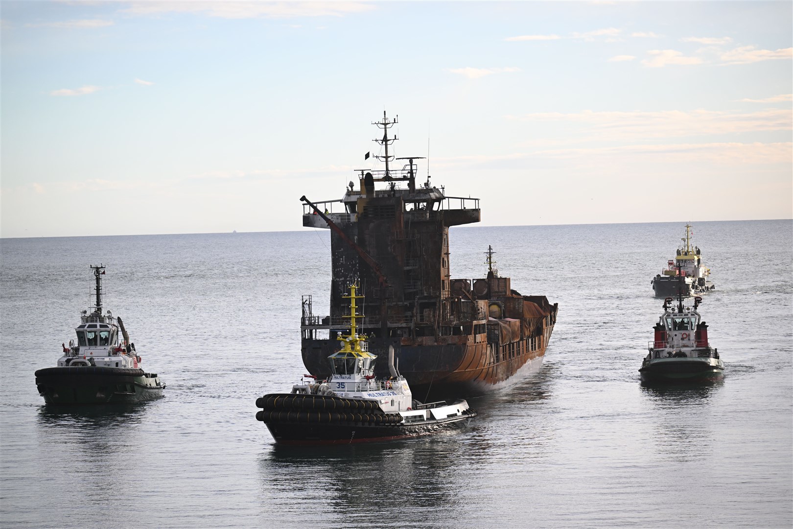 The stricken container ship, the Solong, which was involved in a collision with a tanker in the North Sea, is towed in to the port of Aberdeen (Michal Wachucik/PA)