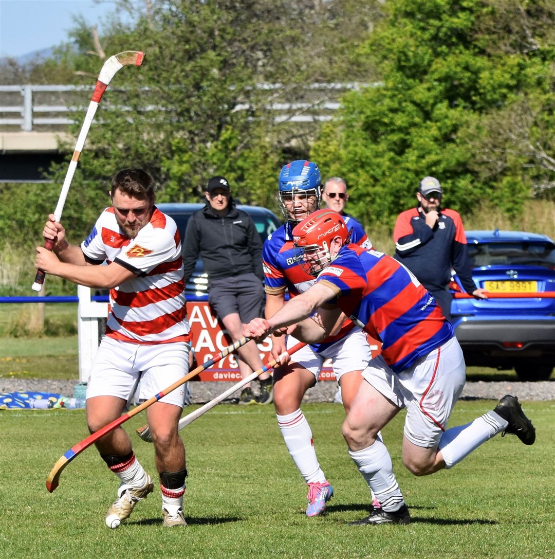 Iain Fraser (middle) and Savio Genini stretch to block Ben Delaney's shot for Lochaber. Picture: Fiona Young.