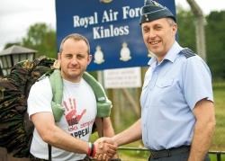 Cpl Andy Souness is welcomed back by station commander Group Captain J.J. Johnston