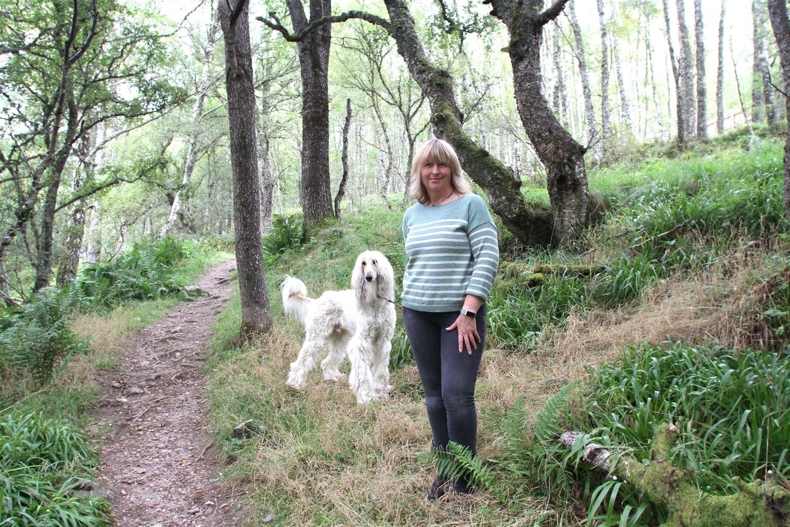 CNPA board member Pippa Hadley, also a local Highland councillor for the Scottish Greens, believes the benefits of carbon off-setting and re-wilding are not being properly highlighted. She is pictured out walking in local woods with her dog Hunter.
