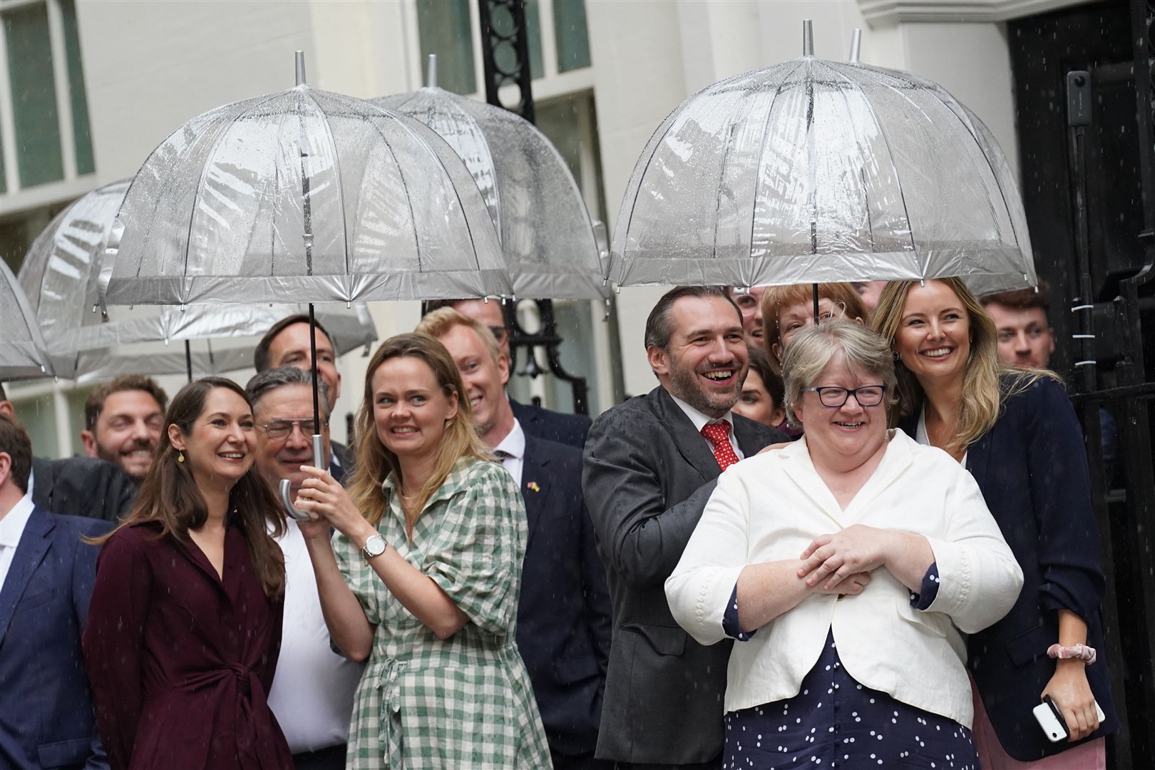 Therese Coffey (right) grins beneath an umbrella ahead of Liz Truss’ arrival at Downing Street on Tuesday (Stefan Rousseau/PA).