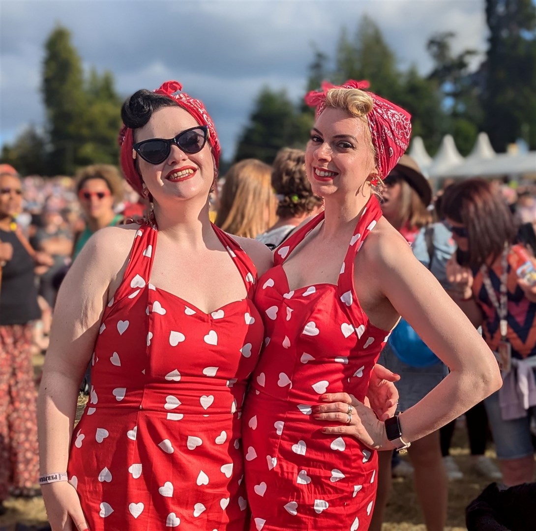 Two ladies dressed in bright red dresses.