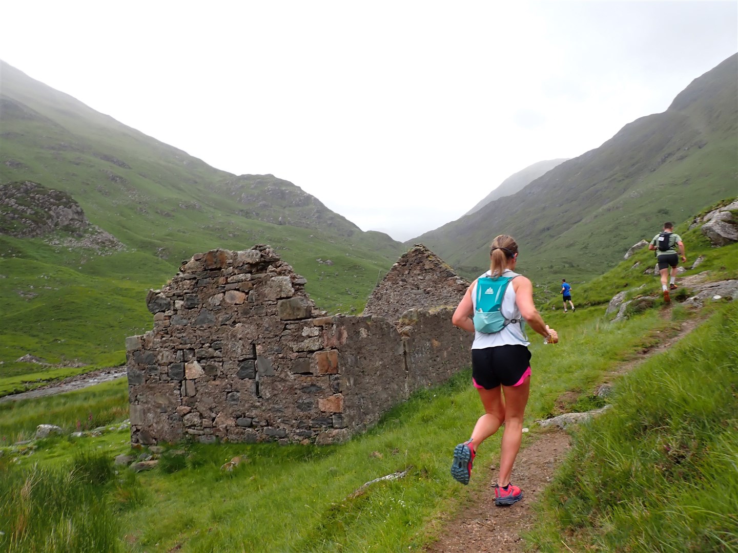 Runners head past a ruin in Gleann Lichd before the climb to the waterfall.