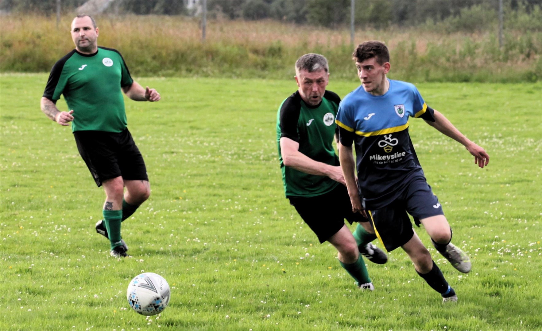 The host’s Alex Williamson (right) has time to look up as Abernethy’s Lee Davies gives chase with Gary McHendry (left) looking on.